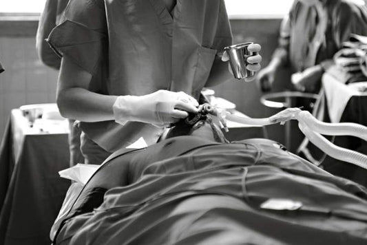 Healthcare professional wearing splash-resistant uniforms in healthcare during a medical procedure.