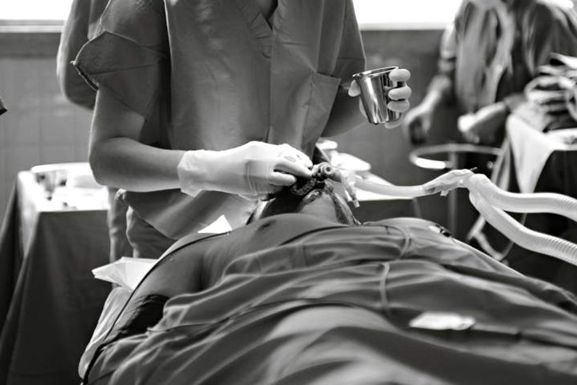 Healthcare professional wearing splash-resistant uniforms in healthcare during a medical procedure.