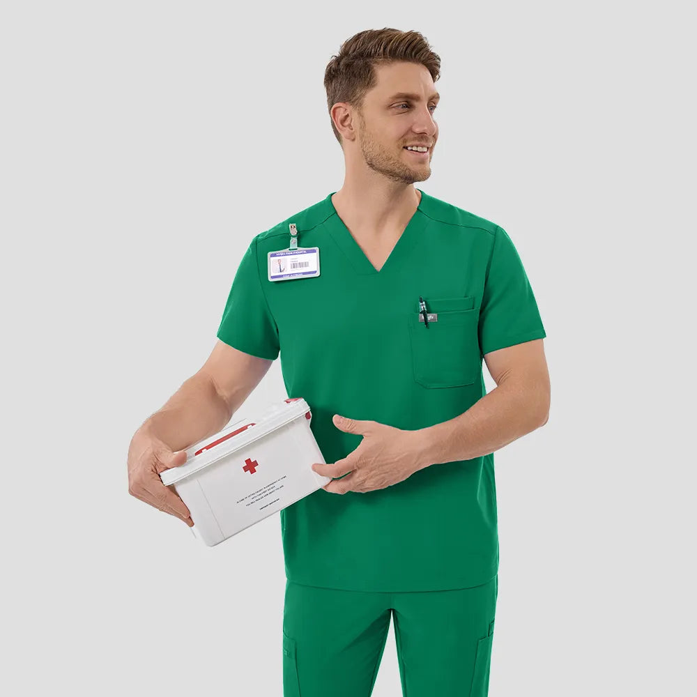 Male model smiling in Indocyanine Green scrub set, front view.